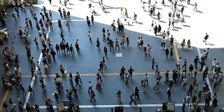 在日本大阪车站的高峰时段，一群无名的人走在人行道上。慢动作镜头