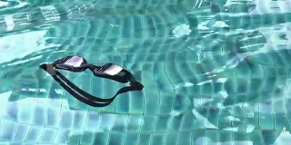 特写泳镜漂浮在游泳池上