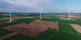 风电场站在绿色的田野上，风力发电机的背景是蓝天和浮云，晴天，全景，空中，四旋翼，欧洲，德国，巴伐利亚