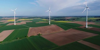 风电场矗立在绿色的田野上，风力发电机的背景是蓝天和浮云，晴朗的一天，欧洲，德国，巴伐利亚