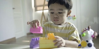 亚洲婴儿玩彩色塑料砖