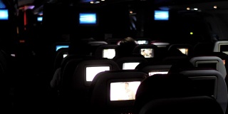 人们晚上在飞机上看娱乐节目