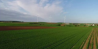 从空中俯瞰农田和风力发电机发电的景象。获得可替代风能的现代技术。鸟瞰图