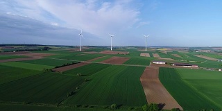 从空中俯瞰农田和风力发电机发电的景象。获得可替代风能的现代技术。鸟瞰图