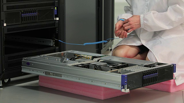 年轻的IT技术员在维护超级计算机时使用电子接地腕带