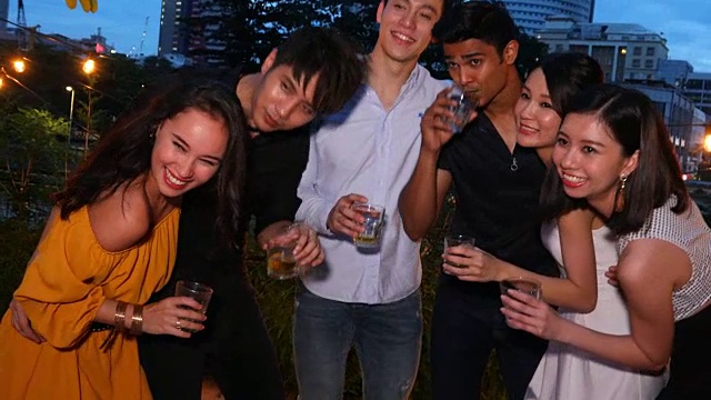 一群亚洲年轻人在屋顶上聚会和敬酒的视频
