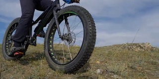 胖自行车或胖轮胎的自行车在夏天开车穿过山丘。