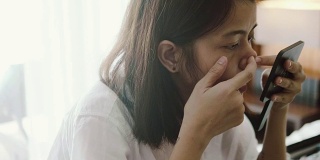 亚洲女人挤她的鼻子上的丘疹。