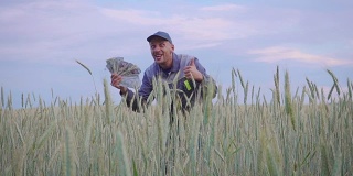 一个成功快乐的年轻农民有很多钱。农业商业成功的概念。