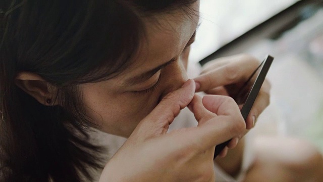 亚洲女人挤她的鼻子上的丘疹。