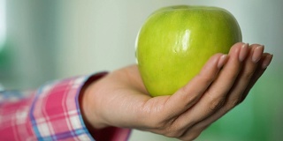 女性手捧青苹果，有机食品为健康和美丽，特写
