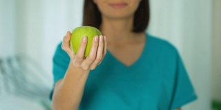 女医生提供青苹果、健康生活方式饮食理念、牙科护理