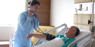 护士在病床上给老人量血压