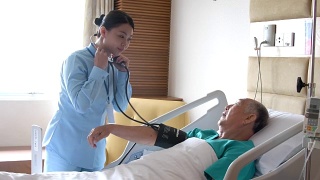 护士在病床上给老人量血压视频素材模板下载
