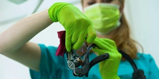 女牙医擦拭放大镜，专业设备，现代诊所