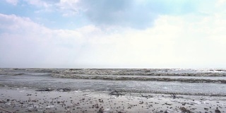多云，具有热带海景和海滩。镜头。海滩和海浪。海浪在阴天。慢动作