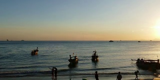 夕阳西下的奥南海滩上的长尾船