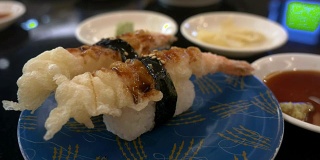 在日本餐厅的酒吧里，寿司装在盘子里