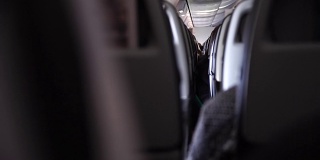 飞机内部，座位上有乘客。湍流引起的摇晃