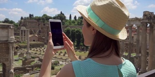 一名女子在罗马广场附近用手机拍照。女游客在罗马广场拍照
