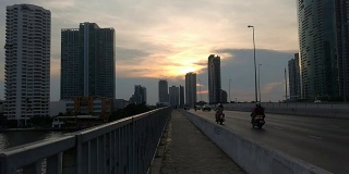 时间流逝的观点，现代建筑背景城市曼谷在傍晚日落。旅行的人在路上。