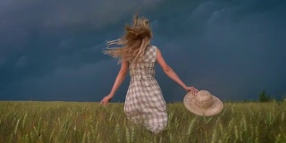 年轻美丽灵感女孩的剪影是在雨天的田野里奔跑，自由的概念