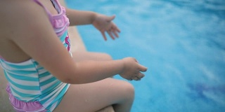 可爱的小女孩在池子里泼水