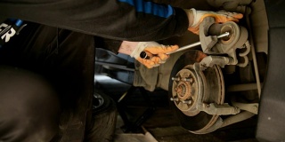 汽车修理工在一家汽车修理厂修理刹车。
