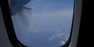 从飞机上俯瞰马尔代夫的一个热带岛屿的海滩，这里有白色的沙滩和水上小屋。