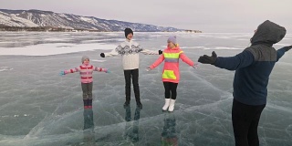 一家人在大自然的冰上进行体育锻炼。父亲在冬天训练他的家人。母女和儿子看着他的训练课。孩子们试着重复。运动前的标准拉伸。