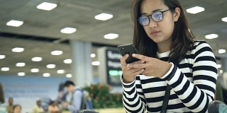 一名泰国女子在机场使用智能手机
