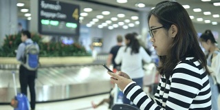 一名泰国女子在机场使用智能手机