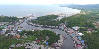 风景优美的海滨村庄，弯曲的河流和海洋背景，航拍视频