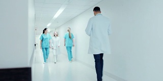 繁忙的现代医院大楼走廊，工作人员行走，工作。专业护士、医生和人员忙碌着他们的一天。