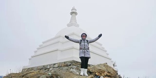 女人在贝加尔湖冰面上的旅行。闭关独特的佛塔布尔可汗纪念碑象征神秘的历史仪式岛大井山水山萨满教崇拜。冬岛之旅。