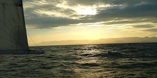 日落时沿山海岸的帆船比赛