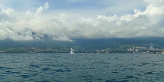 美丽的海景，多山的海岸与云和帆船在海上