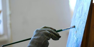 手的女艺术家在手套画画与油画颜料。在工作室工作的天才女孩的过程。4 k