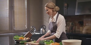 美丽的女人在厨房切新鲜的蔬菜。用红色史诗电影摄像机拍摄。