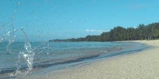 慢镜头:一个活跃的年轻人在潮湿的沙滩上慢跑。