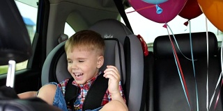 孩子的生日。快乐的孩子在车里。喜庆心情，笑一笑，欢声笑语。汽车里的气球。