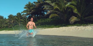 慢镜头:快乐的人在浅海中奔跑，溅起周围的水