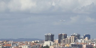 一架双引擎飞机在葡萄牙里斯本市的跑道上着陆。后视图