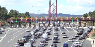 汽车经过收费高速公路点，收费站靠近大桥。葡萄牙里斯本