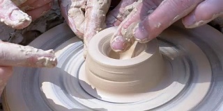 陶工的手在陶工轮上用粘土制作陶器