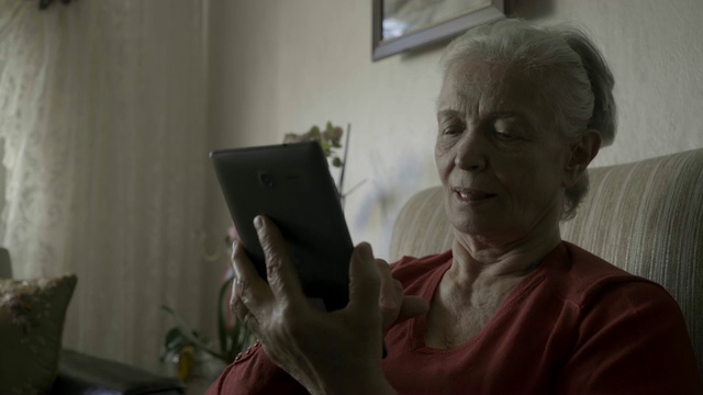 一个老太太正在用平板电脑视频通话