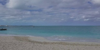 在一个多云的日子沿着格雷斯湾，普罗维登夏莱斯，特克斯和凯科斯群岛的海滩