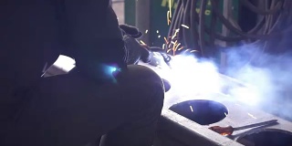 焊工正在工厂里焊接一个金属构件。