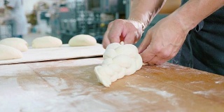 专业面包师正在烘焙商用厨房里制作面团。