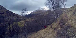 一名旅行者在苏格兰格伦芬南的小路上行走的4K视频